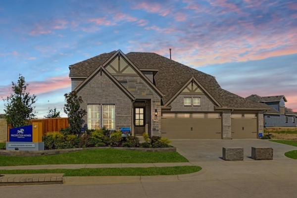 Richardson model home exterior at Leonard Trails in Anna, TX with three-car garage and landscaped front yard at dusk