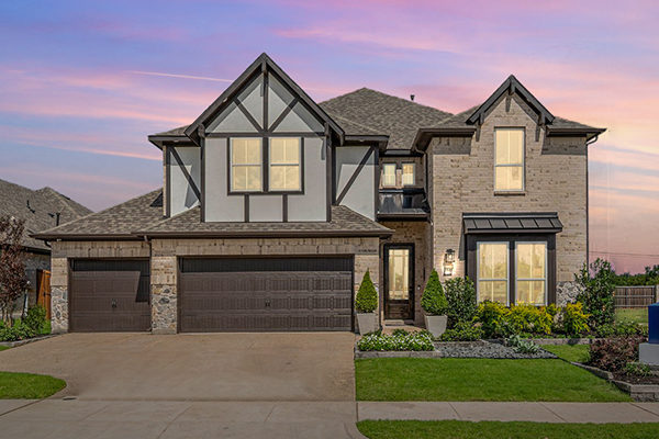 Two-story Westbury model home exterior with stone and brick facade in Meadow Run