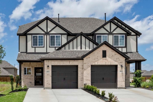 Front exterior of two-story brick townhome with dual garages at 455 Sweet Spring Drive in Lavon, Texas