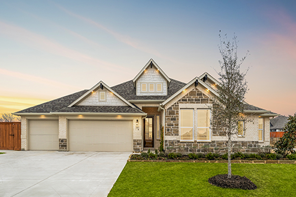 Exterior of the Westlake II model home with brick and stone elevation at Heartland in Heartland, TX.